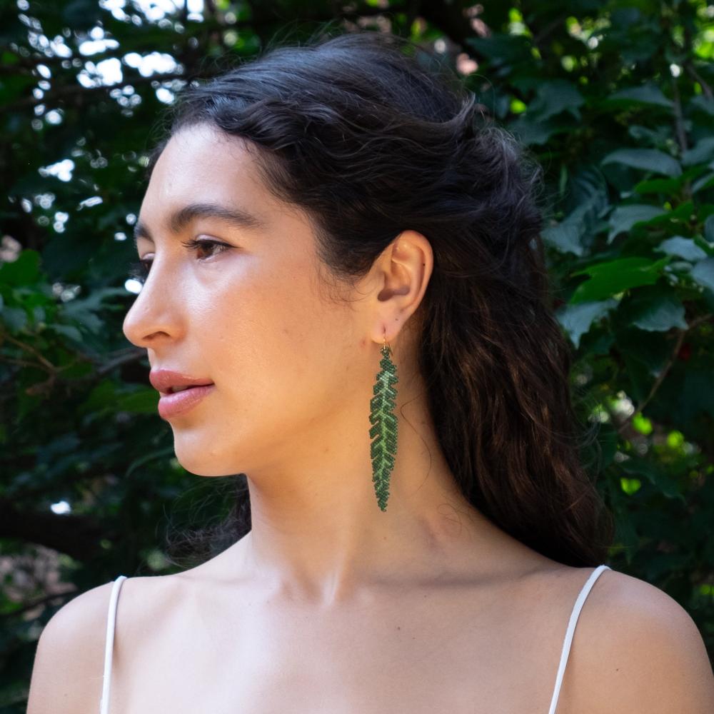 Colombian model wearing Banana Leaf earrings made of glass beads