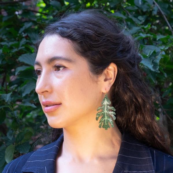 Colombian model in blue blazer and oak leaf earrings made of glass beads. 