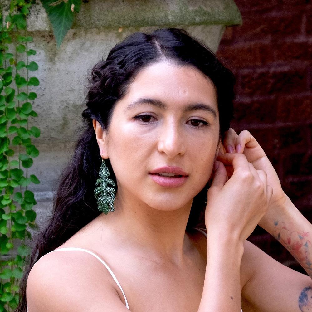 Colombian model wearing oak leaf earrings of glass beads.